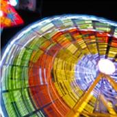 A colorful ferris wheel with many lights in the background.