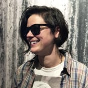 A woman with short hair wearing sunglasses and smiling.