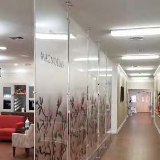 A hallway with glass walls and a red couch.