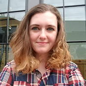 A woman with long hair wearing a plaid shirt.