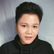 A woman with short hair wearing black is posing for the camera.